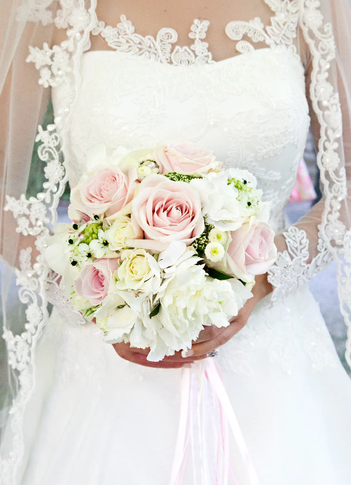Braut mit Brautstrauß aus rosa und weißen Rosen
