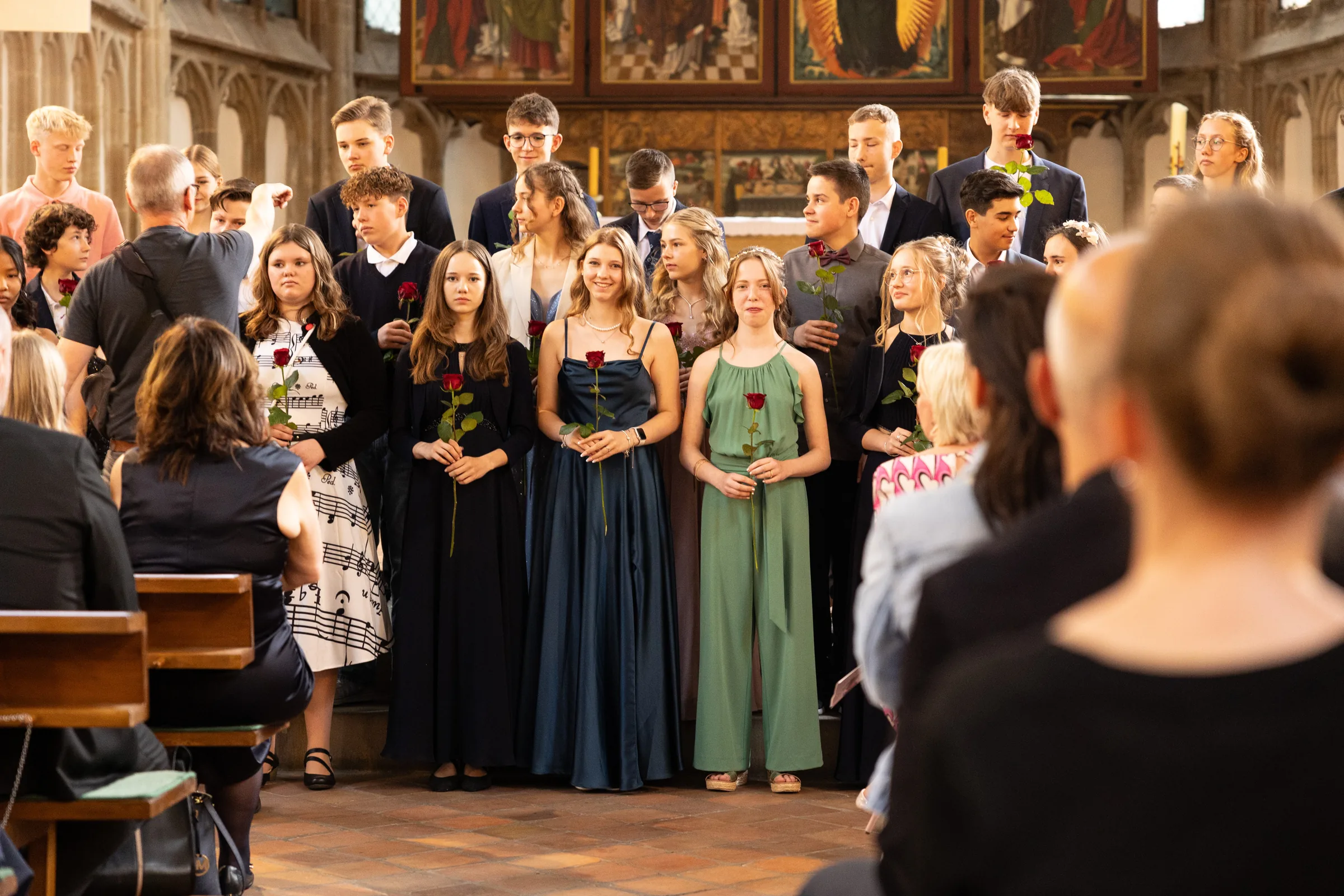 Jugendliche mit roten Rosen bei der Jugendweihe in der Kirche